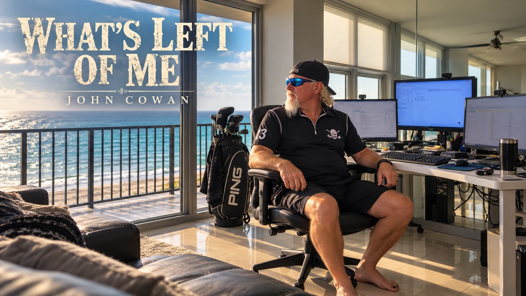 John beside his three-monitor desk looking toward the ocean, with his PING golf bag nearby